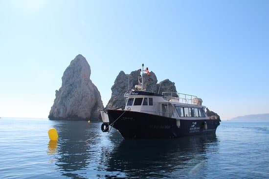 La barca del diving ormeggiata accanto ai faraglioni delle isole Medas