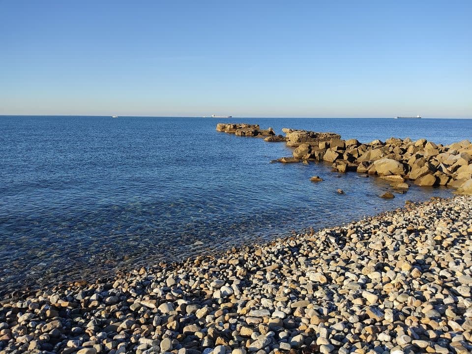 La spiaggia di ciottoli del Marangone con la scogliera, a Civitavecchia