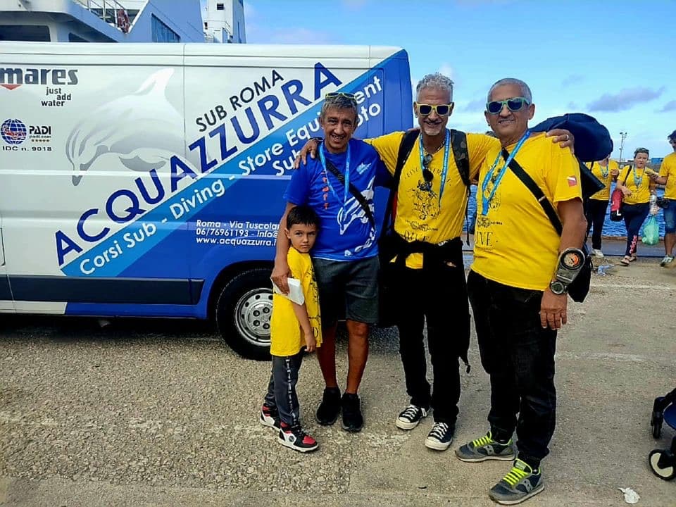 Lo staff di Acquazzurra con un bambino davanti al furgone del negozio