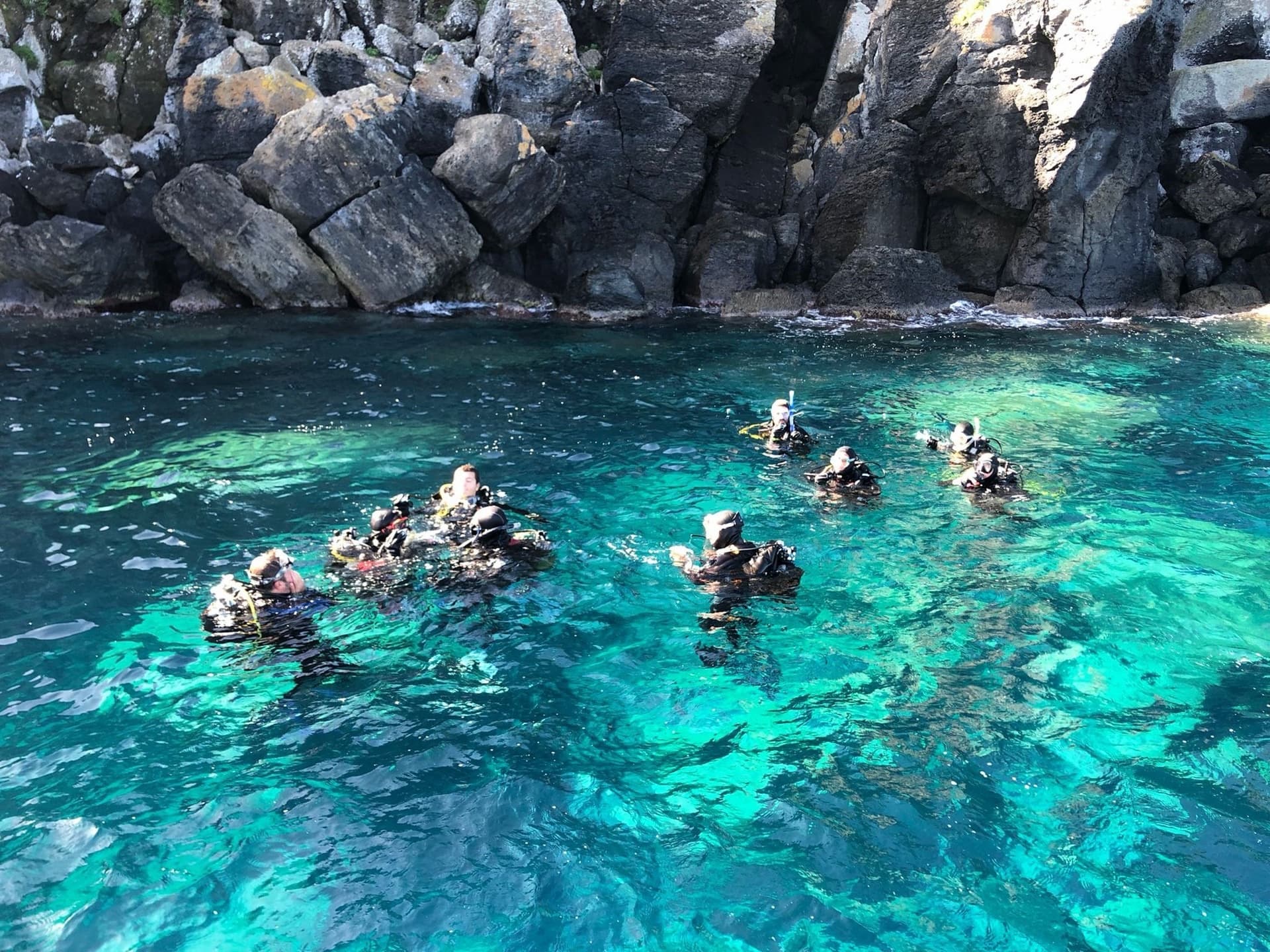 Subacquei in superficie nell'acqua turchese sotto le scogliere di Ventotene