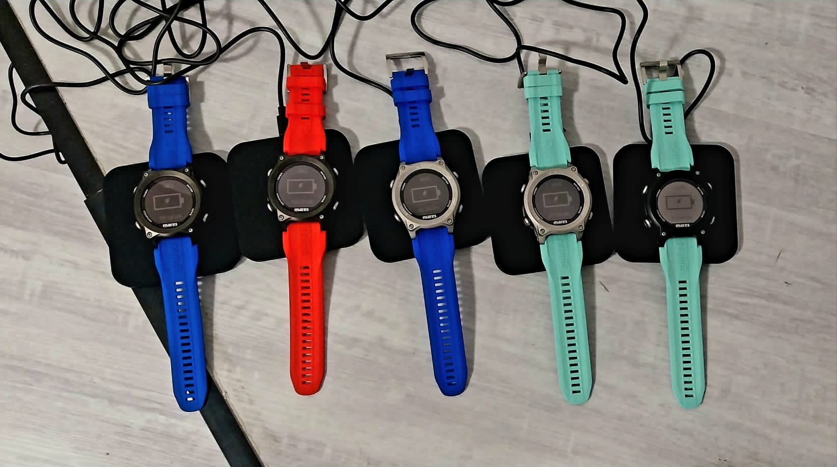 Cinque computer Mares Sirius in fila, con cinturini blu, rosso e acquamarina