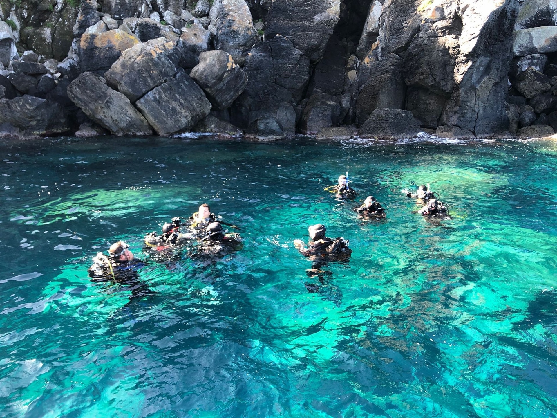 Subacquei in superficie nell'acqua turchese sotto le scogliere di Ventotene