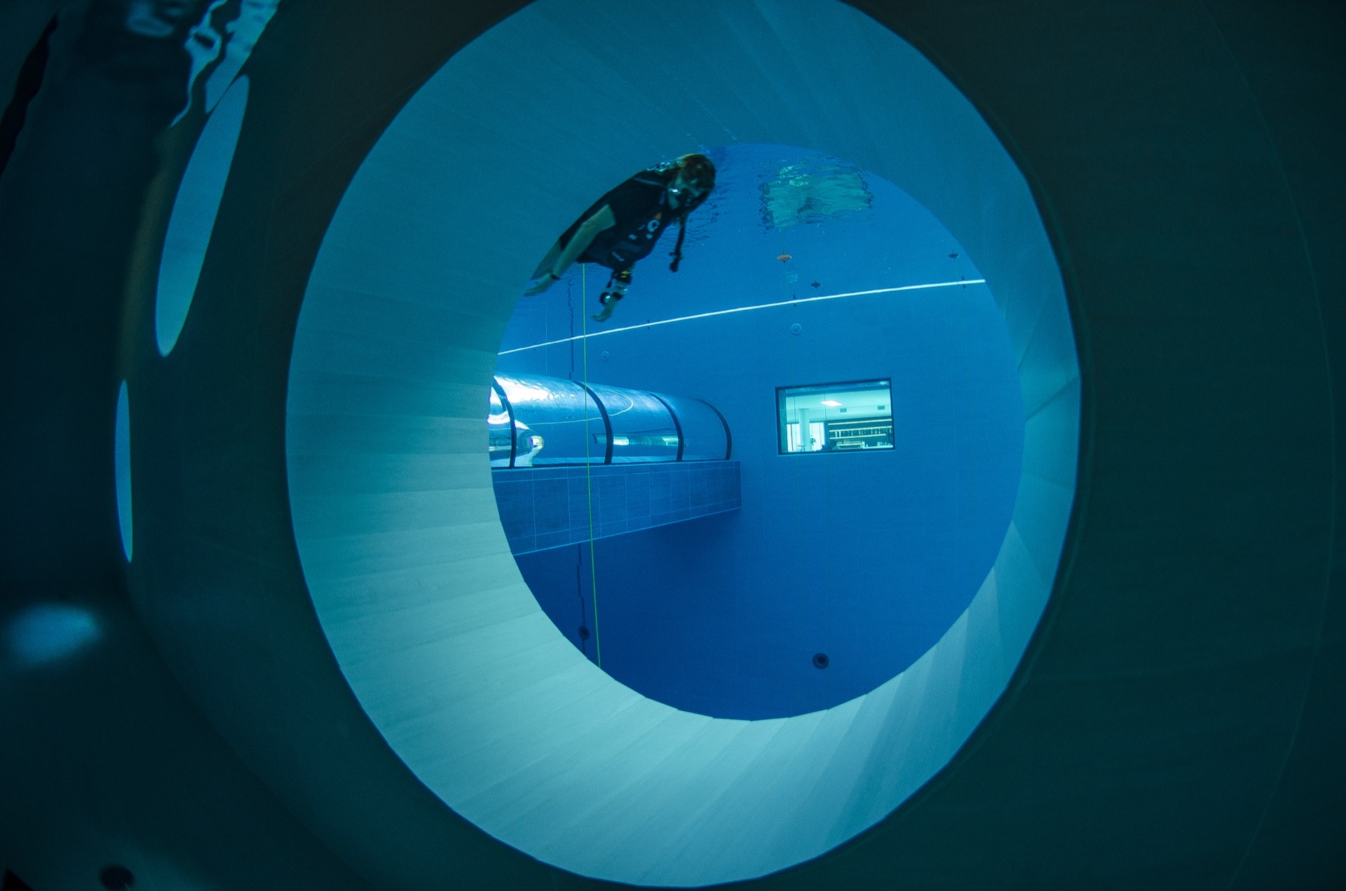 Subacqueo che passa davanti a un oblò nella piscina profonda Y-40