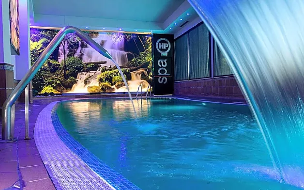 La piscina interna con cascata dell'area spa dell'hotel
