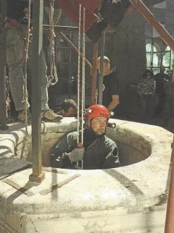 Speleosubacqueo con il casco che si cala in un pozzo antico
