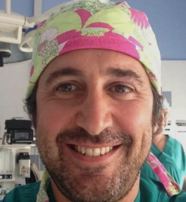 Ritratto sorridente di uno dei relatori, con la cuffia chirurgica